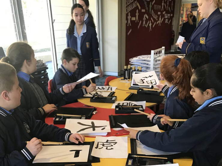 Students painting Japanese symbols