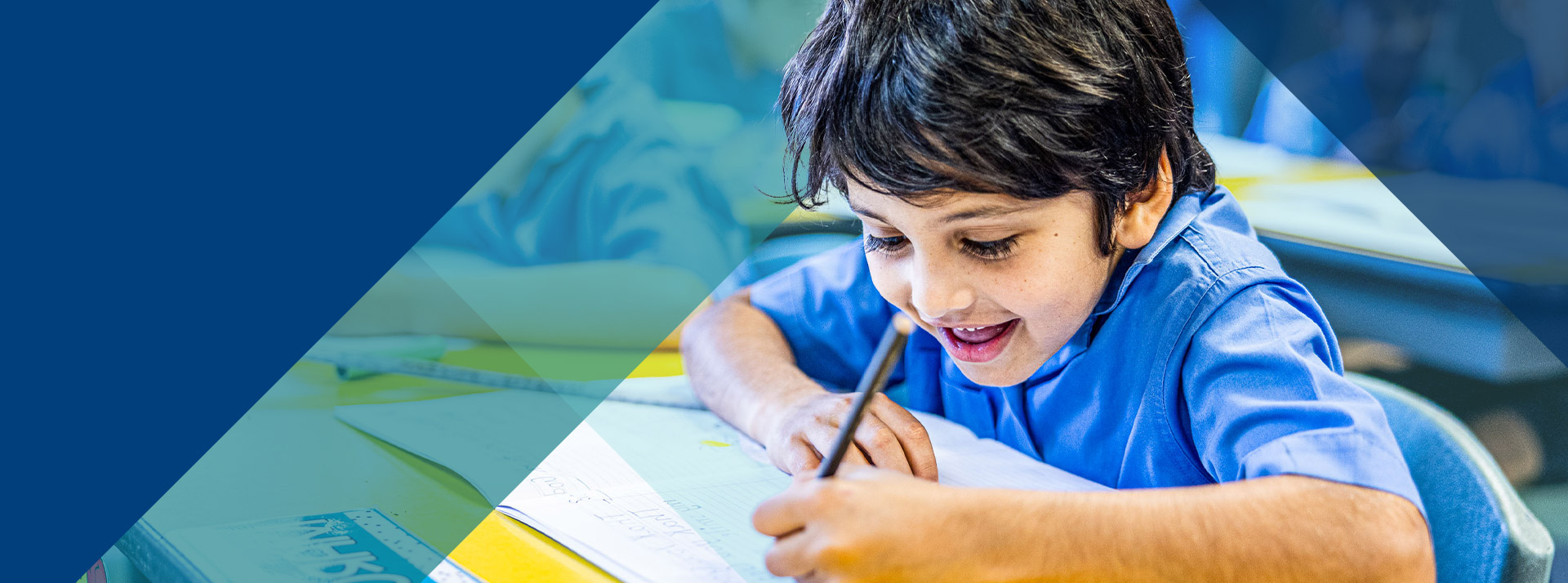 Student writing at his desk in the classroom at Our Lady of Lourdes Primary School Baulkham Hills South