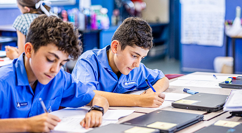 Students writing at their desks in the classroom at Our Lady of Lourdes Primary School Baulkham Hills South